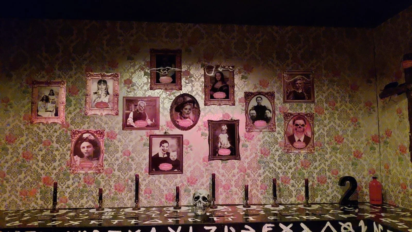 Sala Escape Room temática Familia Addams con retratos y mesa Ouija