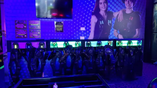 Zona LASER TAG con neón rosa y equipo en pared